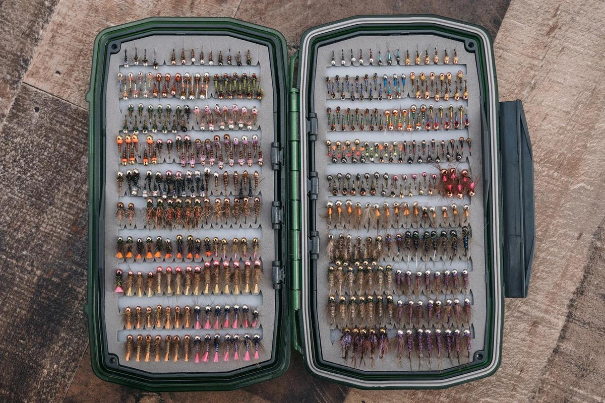 Umpqua UPG Foam Waterproof Ultimate Nymph Fly Box filled with colorful beadhead nymph flies in organized rows.