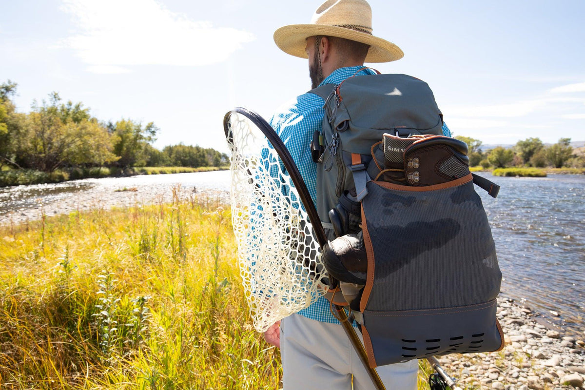 Angler wearing Fishpond Firehole Backpack on a backcountry fishing adventure